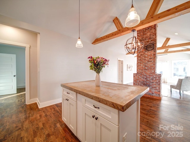 kitchen featuring beamed ceiling, decorative light fixtures, a kitchen island, and white cabinetry