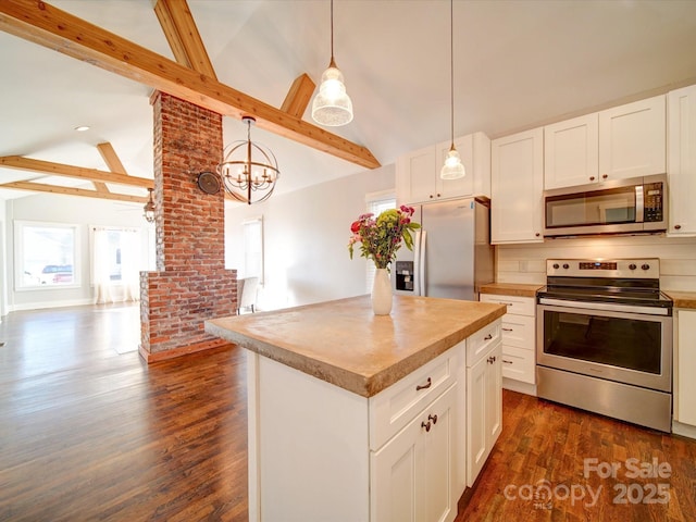 kitchen with appliances with stainless steel finishes, pendant lighting, white cabinetry, beamed ceiling, and a kitchen island