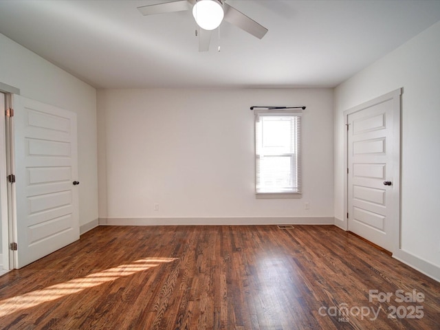 unfurnished room with ceiling fan and dark hardwood / wood-style floors