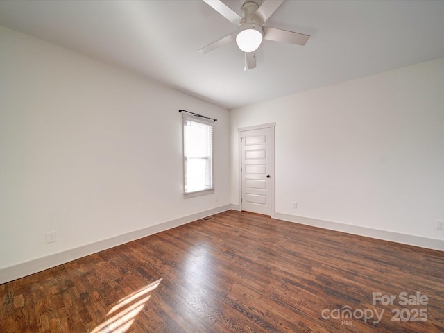 empty room with ceiling fan and dark hardwood / wood-style flooring