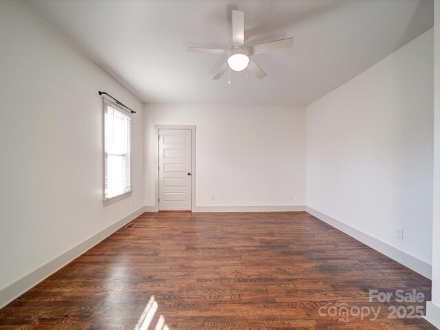 unfurnished room featuring ceiling fan and dark wood-type flooring