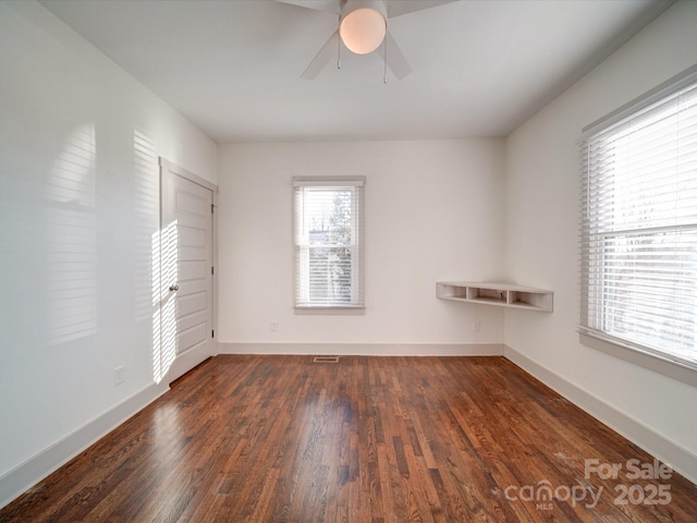 unfurnished room with ceiling fan and dark wood-type flooring