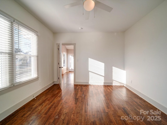 empty room with ceiling fan and dark wood-type flooring