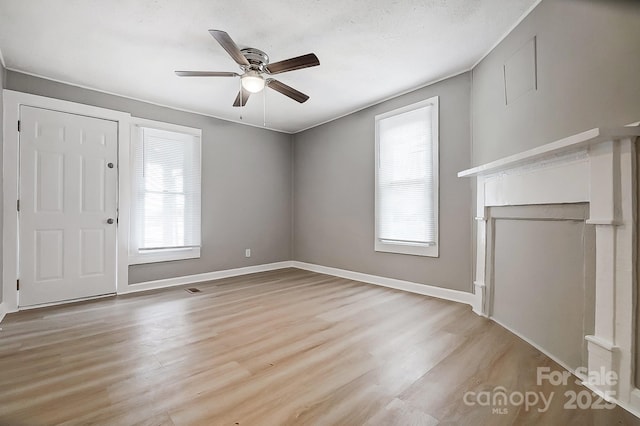 unfurnished living room with plenty of natural light, light hardwood / wood-style floors, and ceiling fan