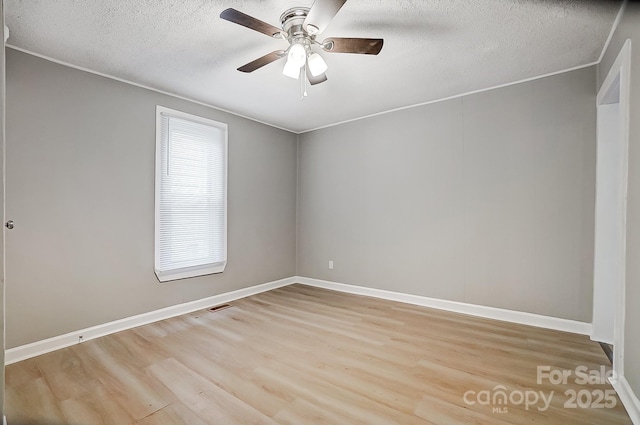 spare room featuring a textured ceiling, light hardwood / wood-style flooring, ceiling fan, and a healthy amount of sunlight