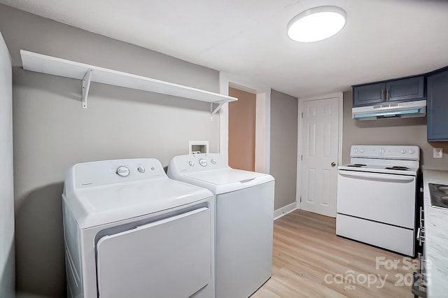 laundry room with washer and clothes dryer and light hardwood / wood-style flooring