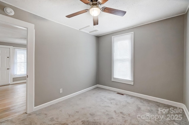 carpeted spare room featuring ceiling fan