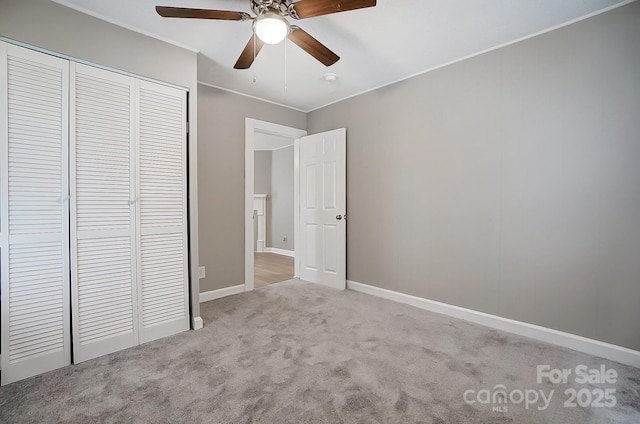 unfurnished bedroom featuring ceiling fan, light colored carpet, and a closet