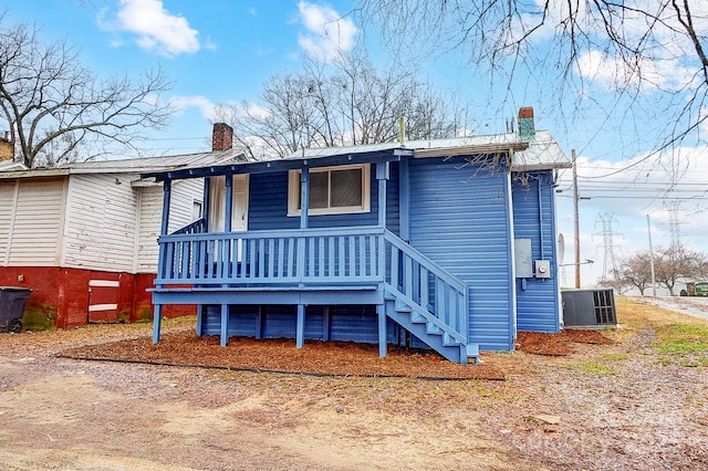 view of front facade with covered porch and central AC