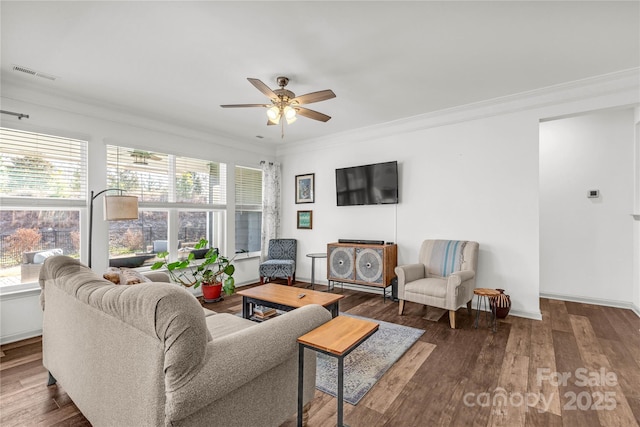 living room with ceiling fan, crown molding, and dark wood-type flooring