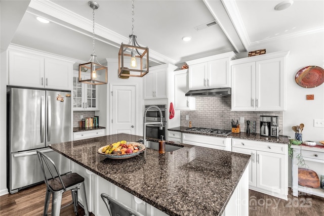 kitchen featuring beam ceiling, white cabinetry, an island with sink, and appliances with stainless steel finishes