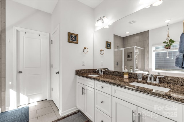 bathroom with tile patterned flooring, vanity, and walk in shower