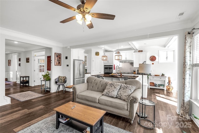 living room with dark hardwood / wood-style floors, ceiling fan, and crown molding