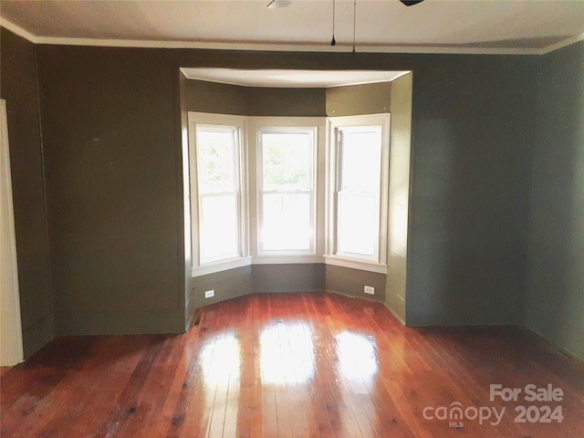 unfurnished room featuring dark hardwood / wood-style flooring and ornamental molding