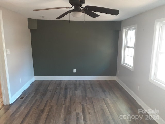 empty room with ceiling fan and dark hardwood / wood-style flooring