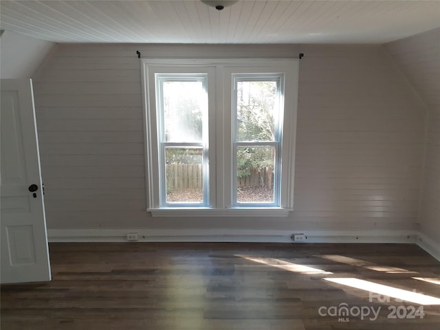 additional living space with dark hardwood / wood-style flooring and vaulted ceiling