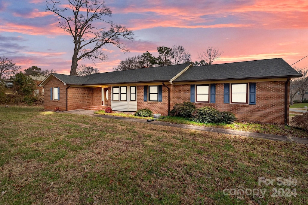 ranch-style home with a lawn