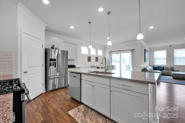 kitchen with sink, tasteful backsplash, a center island with sink, white cabinets, and appliances with stainless steel finishes