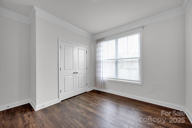 unfurnished bedroom with ornamental molding, dark wood-type flooring, and a closet