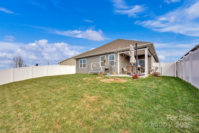 rear view of house featuring a patio area and a yard