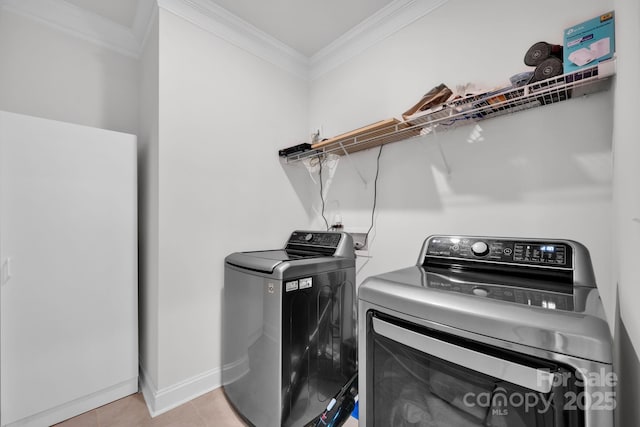 clothes washing area featuring washing machine and clothes dryer, light tile patterned floors, and ornamental molding