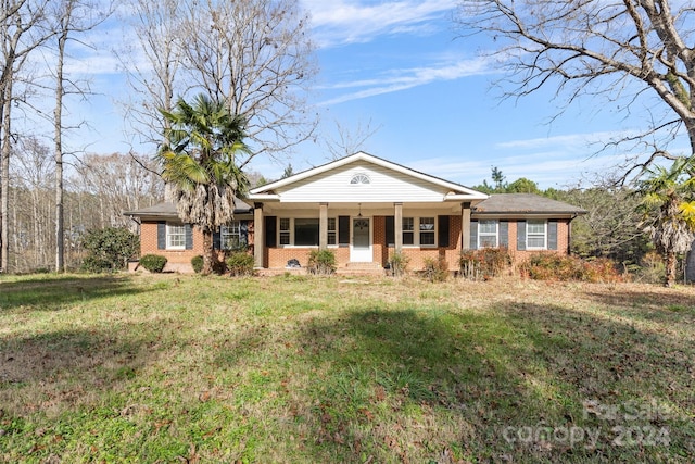 ranch-style home with covered porch and a front yard