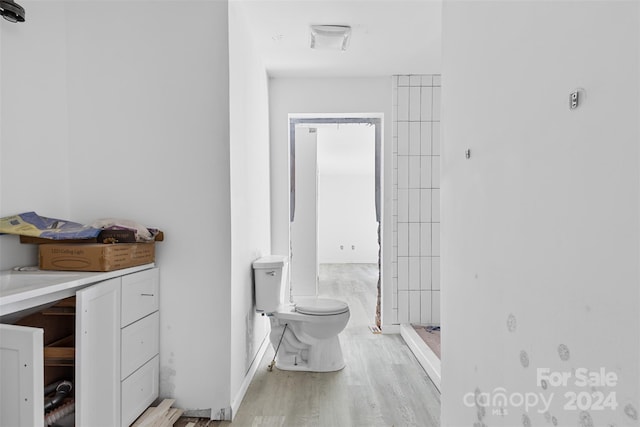 bathroom with a shower, hardwood / wood-style floors, and toilet