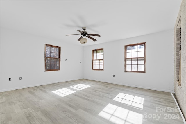 empty room with ceiling fan and light hardwood / wood-style floors