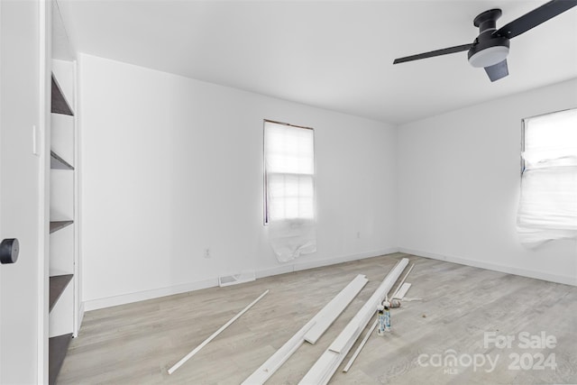 spare room with ceiling fan, a healthy amount of sunlight, and light hardwood / wood-style flooring