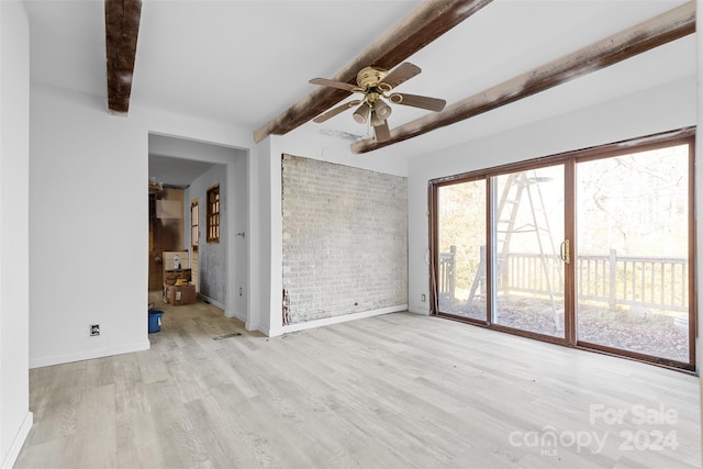 unfurnished living room with beam ceiling, ceiling fan, light hardwood / wood-style flooring, and brick wall