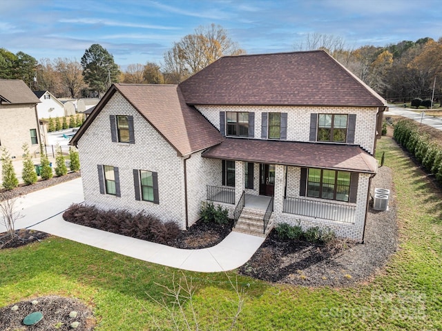 front of property with central air condition unit, a front lawn, and a porch