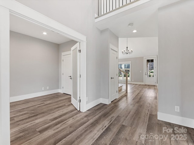 interior space with dark hardwood / wood-style flooring, a towering ceiling, and an inviting chandelier