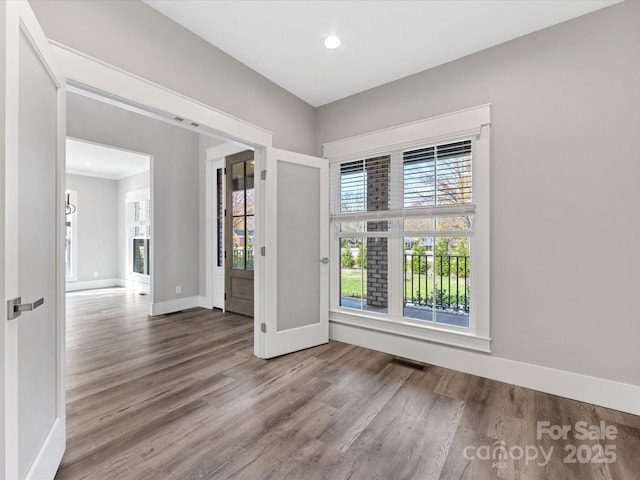 unfurnished room with hardwood / wood-style flooring and a wealth of natural light