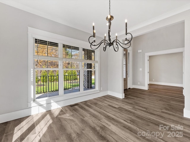 unfurnished dining area with hardwood / wood-style floors and an inviting chandelier