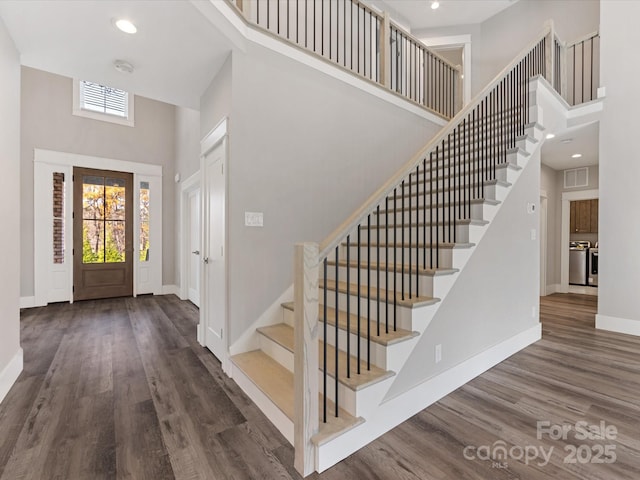 entryway featuring dark hardwood / wood-style flooring and a high ceiling