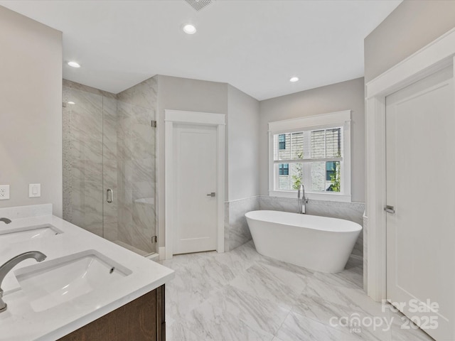 bathroom featuring vanity and independent shower and bath