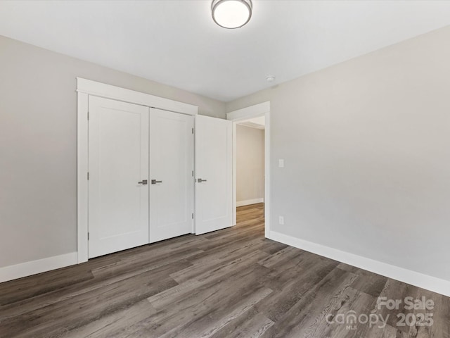 unfurnished bedroom with a closet and dark hardwood / wood-style floors