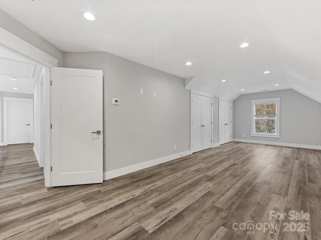 bonus room featuring light wood-type flooring and vaulted ceiling