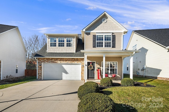 view of front of house with a front lawn, covered porch, and a garage