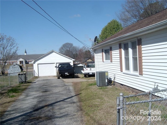 view of side of property featuring an outbuilding, cooling unit, and a garage