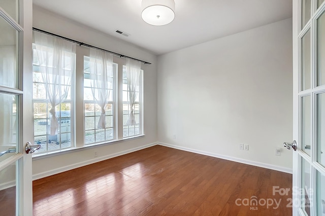 unfurnished room with a wealth of natural light and wood-type flooring