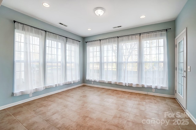 empty room featuring a wealth of natural light and light tile patterned flooring