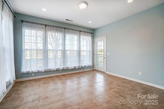 tiled spare room featuring plenty of natural light