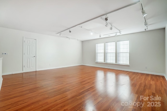 spare room with hardwood / wood-style floors and track lighting