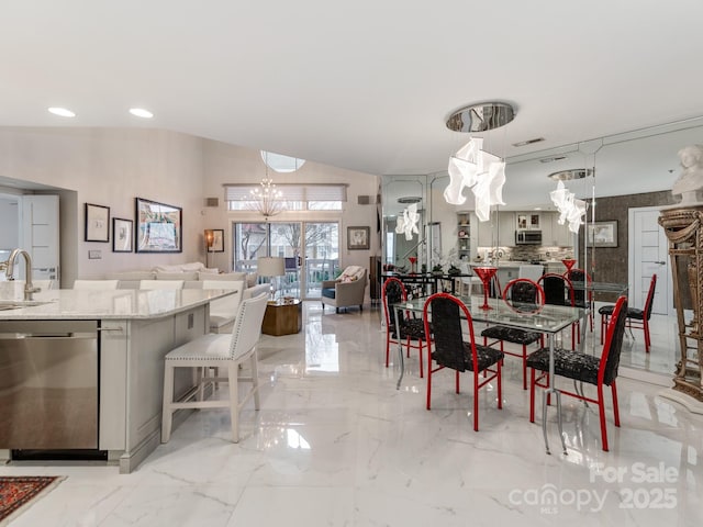 dining space featuring sink, an inviting chandelier, and vaulted ceiling