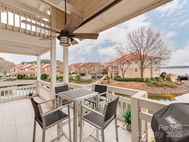 view of patio / terrace featuring grilling area, ceiling fan, a pergola, and a water view