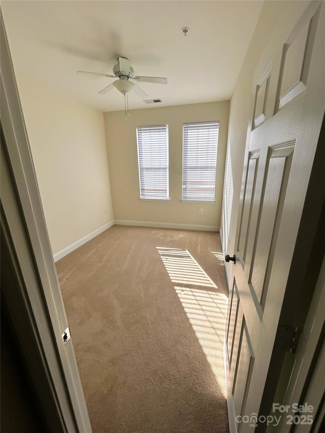 unfurnished room with ceiling fan and light carpet