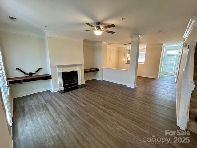 unfurnished living room featuring ceiling fan, ornamental molding, dark hardwood / wood-style floors, and ornate columns