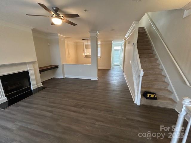 unfurnished living room with crown molding, ceiling fan, and dark hardwood / wood-style floors