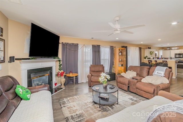 living room featuring light hardwood / wood-style floors and ceiling fan